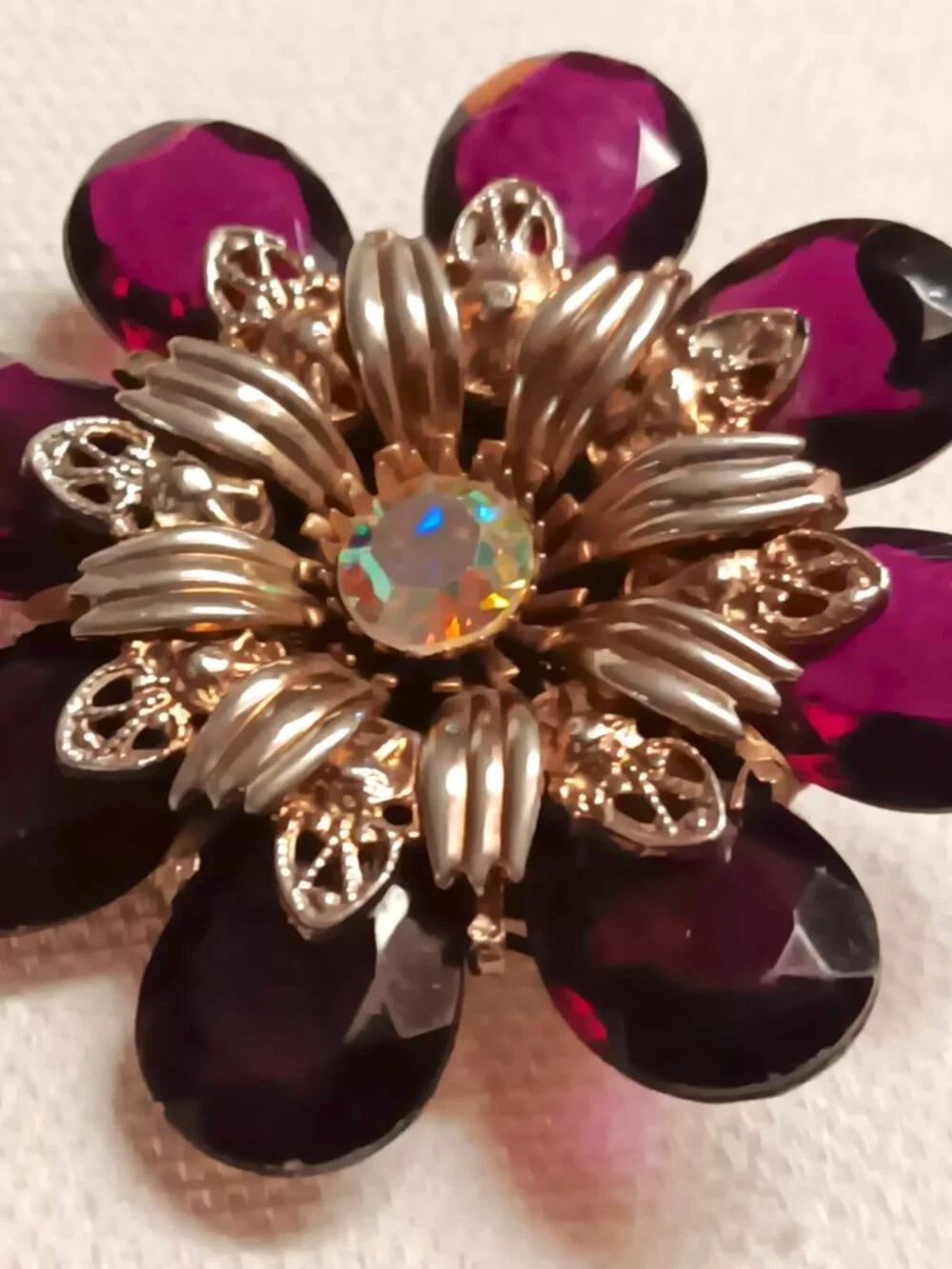 Vintage ruby lucite brooch with aurora borealis central rhinestone.